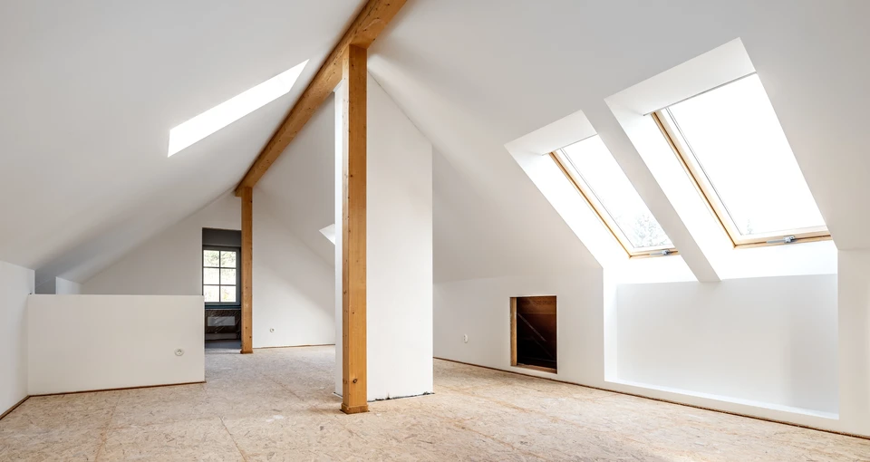Intérieur d'une maison en construction avec charpente bois apparente et isolation thermique entre montants