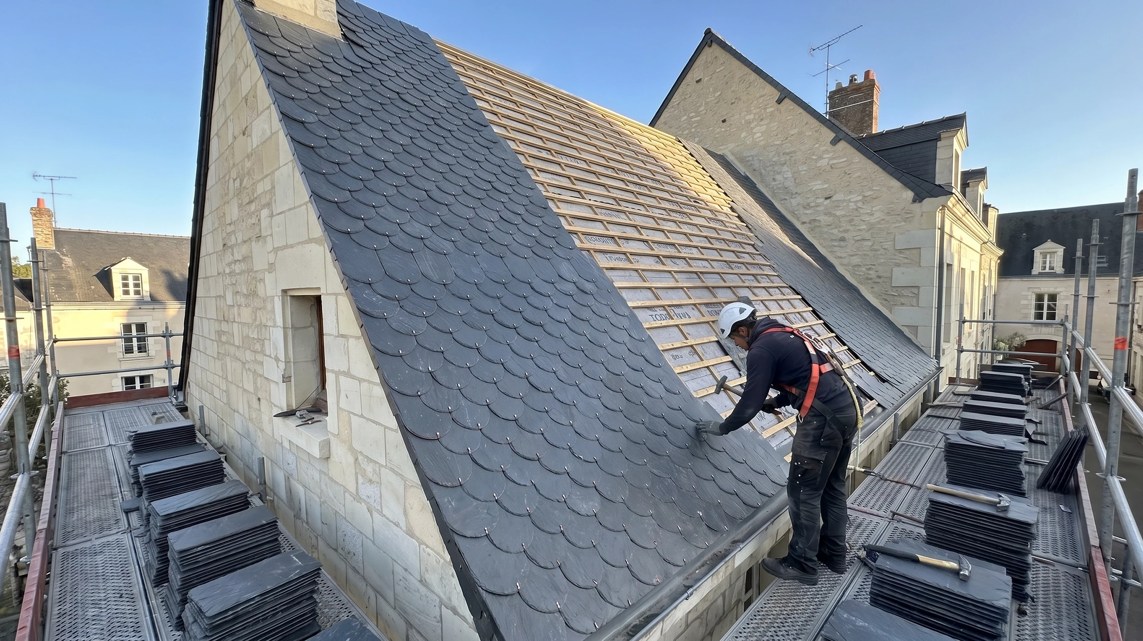Extérieur, vue en contre-plongée d'une toiture en construction sous ciel bleu azur